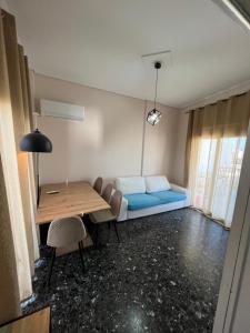 ein Wohnzimmer mit einem blauen Sofa und einem Tisch in der Unterkunft Light Apartment in Ierápetra