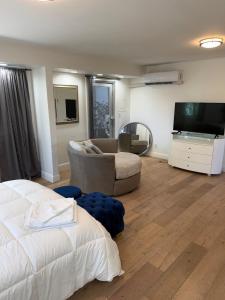 a bedroom with a bed and a flat screen tv at Flip Flops 1 mile beach stadium close in Hollywood