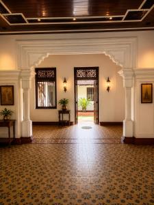 an empty lobby with a large room with white columns at Basnagoda Walawwa in Ruwanwella