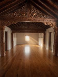 a large room with a wooden floor and an ornate ceiling at Basnagoda Walawwa in Ruwanwella