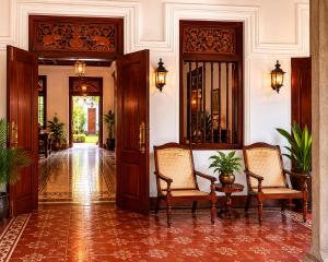 a hallway with two chairs and a table in a building at Basnagoda Walawwa in Ruwanwella