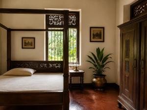 a bedroom with a canopy bed and a window at Basnagoda Walawwa in Ruwanwella