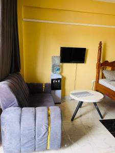 a living room with a couch and a table at Fewa studio in Busia