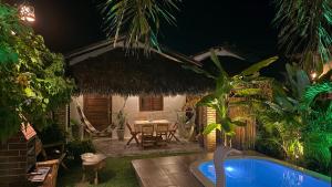 a backyard with a table and a pool at night at Chalé Lampião BG in Barra Grande