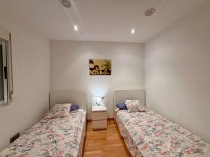 two beds are in a room with white walls at Apartamento con encanto in Monte San Miguel