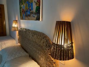 a lamp sitting next to a wicker chair next to a lamp at Chalé Lampião BG in Barra Grande +9 photos