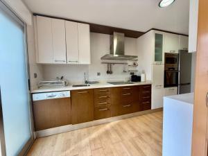 a kitchen with white cabinets and wooden floors at Apartamento con encanto in Monte San Miguel +8 photos