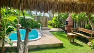 a backyard with a hot tub and a bench at Chalé Lampião BG in Barra Grande