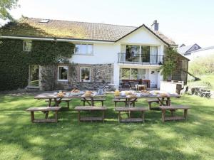 a group of picnic tables in front of a house at Baronheid in Francorchamps