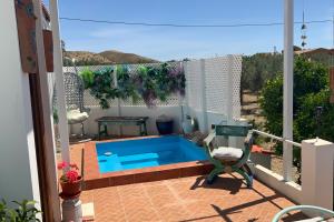 a balcony with a swimming pool and a chair at Quality Rustic Retreat in Tabernas Countryside in Tabernas