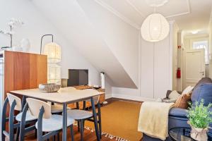 a dining room and living room with a table and chairs at Hillside - By WeHost in Funchal