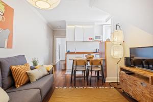 a living room with a couch and a table with chairs at Hillside - By WeHost in Funchal +4 photos