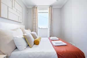 a bedroom with a white bed and a window at Hillside - By WeHost in Funchal