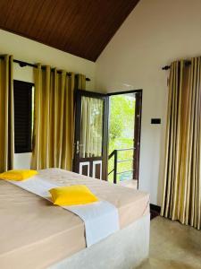 a bedroom with a large bed with yellow pillows at Knuckles Breeze Villas Kandy in Kandy