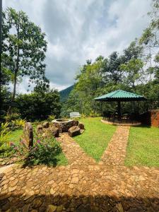 a garden with a picnic table and an umbrella at Knuckles Breeze Villas Kandy in Kandy +7 photos