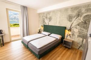 a bedroom with a bed and a large window at Hotel Alesi in Malcesine