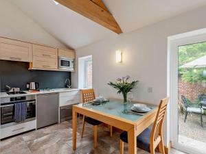 a kitchen with a table and chairs in a kitchen with a table and a table at 1 Bed in Lymington oc-83370 in Sway