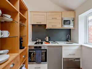 a small kitchen with a stove and a microwave at 1 Bed in Lymington oc-83370 in Sway +8 photos