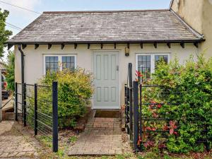 a small white house with a black fence at 1 Bed in Lymington oc-83370 in Sway