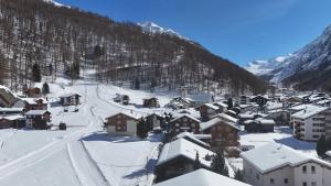 a village covered in snow with a mountain at Cozy single suite with mountain view in Saas-Almagell
