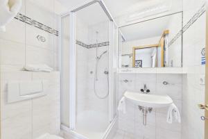 a white bathroom with a shower and a sink at Cozy single suite with mountain view in Saas-Almagell