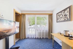 a hotel room with a large window and a desk at Cozy single suite with mountain view in Saas-Almagell