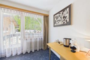 a hotel room with a desk and a window at Cozy single suite with mountain view in Saas-Almagell