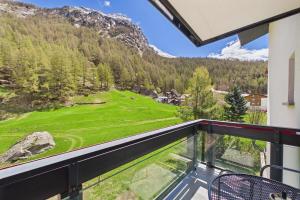 a balcony with a view of a golf course at Cozy single suite with mountain view in Saas-Almagell +4 photos