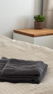 a bed with a gray blanket on it with a plant at VE Apartments Colbitz in Kolbitz