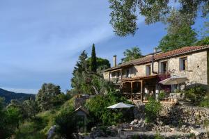a stone house with umbrellas in front of it at Eftihia in Katouna