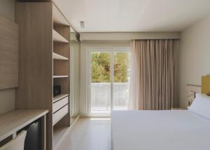 a bedroom with a bed and a large window at Hotel Mediterráneo in Roses