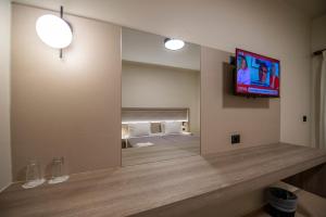 a room with a mirror and a tv on a wall at Falassarna Hotel in Chania