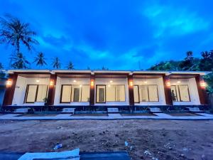 a house with a lot of windows at night at KUTA GLORI Homestay in Kuta Lombok