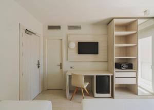 a small room with a desk and a tv at Hotel Mediterráneo in Roses