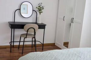 a black desk with a mirror and a chair at Dottygal Fiumei UIA in Balatonboglár +1 photo