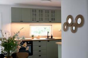 a kitchen with white cabinets and a window at Dottygal Fiumei UIA in Balatonboglár