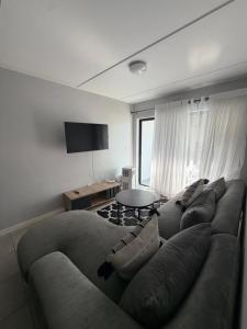 ein Wohnzimmer mit Sofa und Tisch in der Unterkunft Elevare suites in Nelspruit