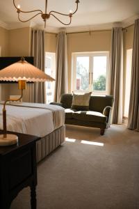 a hotel room with a bed and a couch at Redlands Hotel in Pietermaritzburg