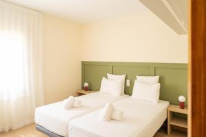 a bedroom with two white beds with white pillows at Majordoms Velo in Llambillas +42 photos