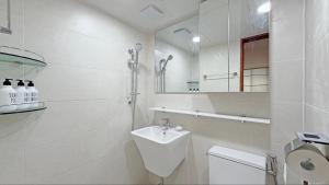 a white bathroom with a sink and a toilet at SOYO-SOOP Stay in Seoul