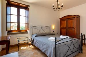 ein Schlafzimmer mit einem Bett, einem Tisch und einem Fenster in der Unterkunft Hotel Dei Templi in Paestum