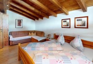 a bedroom with a bed and a couch at Gipfelblick Appartements in Umhausen