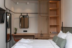 a bedroom with a white bed and a desk at NAEMA Seafront Living 2BR Suite in Anissaras