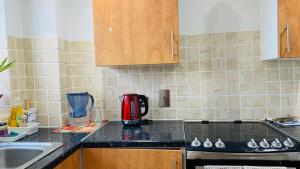 a kitchen with a stove top oven next to a sink at A cosy & peaceful homestay in Sutton