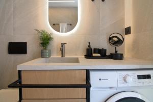 a bathroom with a sink and a washing machine at NAEMA Seafront Living 2BR Suite in Anissaras