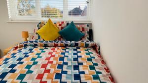 a bedroom with a colorful bed with a window at A cosy & peaceful homestay in Sutton