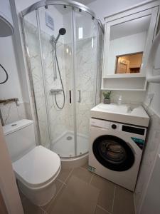 a bathroom with a shower and a washing machine at Welcome Valmiera in Valmiera