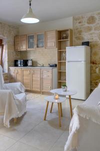 eine Küche mit einem weißen Kühlschrank und einem Tisch in der Unterkunft Bastakis Studio Silver in Skalánion