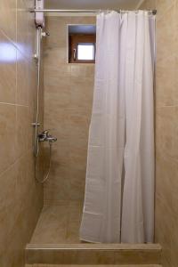 eine Dusche mit weißem Duschvorhang in einem Badezimmer in der Unterkunft Bastakis Studio Silver in Skalánion