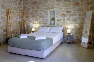 ein Schlafzimmer mit einem großen Bett in einer Steinwand in der Unterkunft Bastakis Studio Silver in Skalánion + 6 Fotos